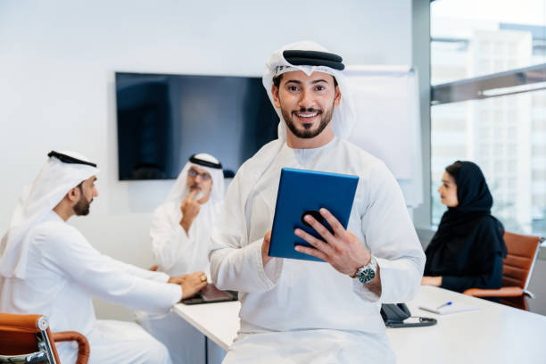 Business professionals discuss Ajman Free Zone license costs in a modern office setting.